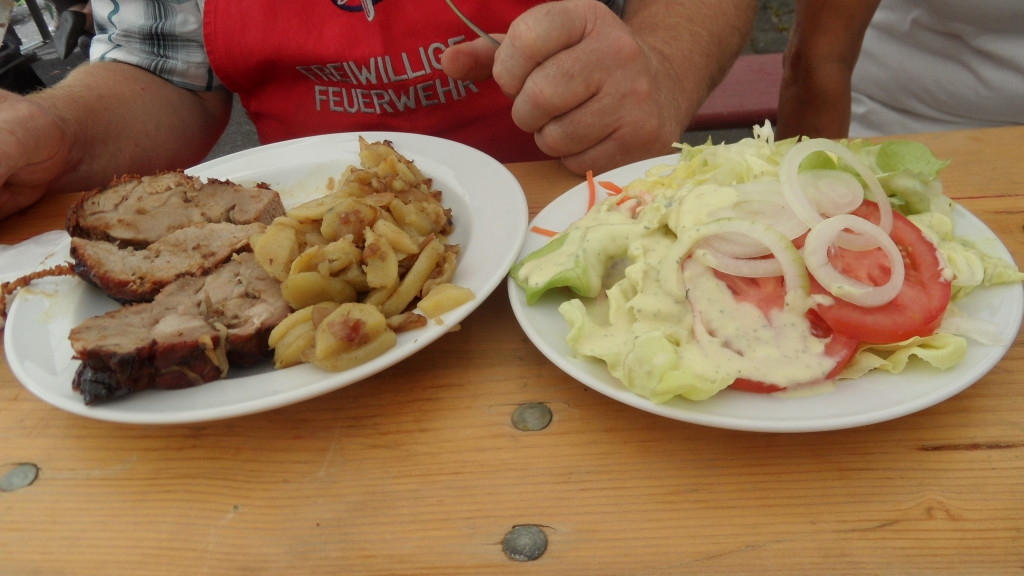 Das Essen auf dem Tisch. Rollbraten, Bratkartoffeln und Salat)