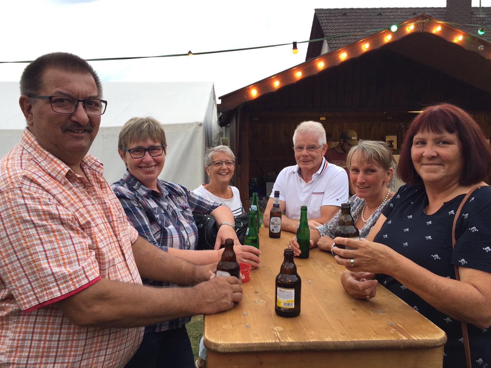 Gäste feiern beim Brunnenfest in der Dorfmitte am Schlachthaus